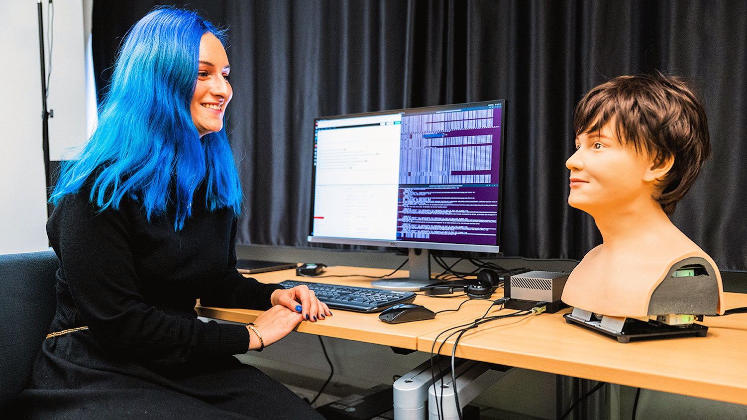 Nachwuchswissenschaftlerin Johanna Kuch bei der Arbeit an "EchoSync": sie untersucht, welche Stimme Menschen im "Gespräch" mit einem humanoiden Roboter angenehm und sympathisch finden. (Quelle: Emil Anwander/Uni Augsburg)